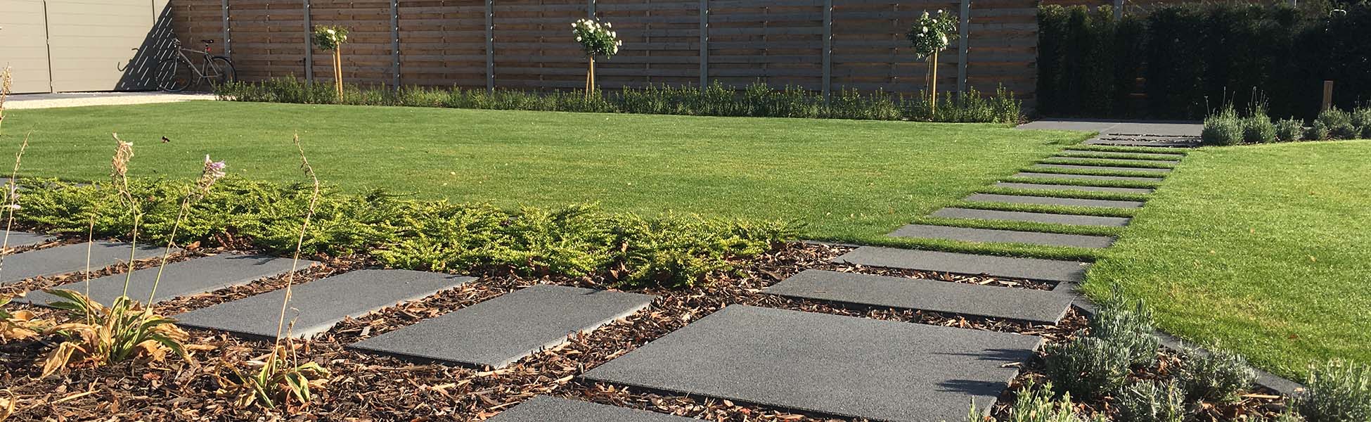 Nieuwbouwtuin met betonpaden en beplante borders aangelegd door Ropatuin